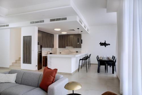 a living room and kitchen with a couch and a table at Oasis Homes by Olala Homes in Ras al Khaimah
