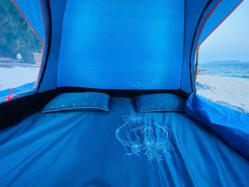 a blue bed in a tent on the beach at Biển Ngọc Homestay Đảo Bé Lý Sơn in Quang Ngai
