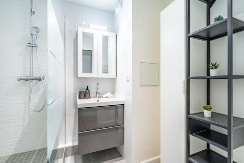 une salle de bain avec un lavabo et une douche dans l'établissement La Suite des Ternes, à Paris