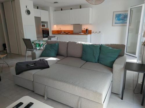 un salon avec un canapé et une cuisine dans l'établissement Lou Cantoun Villa neuve 6 à 8 personnes, à Saubion