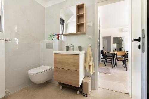 a bathroom with a sink and a toilet and a table at Holiday house Nova in Ližnjan