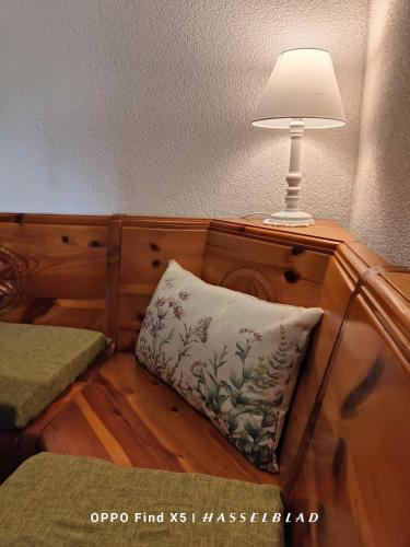 a lamp sitting on top of a wooden cabinet with a pillow at Rustico Cascina Val Malvaglia in Malvaglia