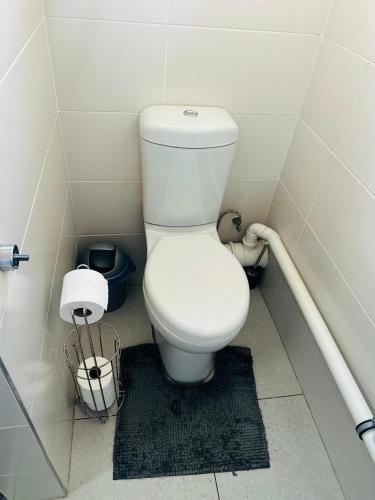 a bathroom with a white toilet in a stall at Cozy One-bedroom Apartment near GrandPalm Resort Block 5, Gaborone, Botswana in Mogoditshane