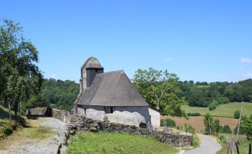 an old stone building with a tower on a hill at Etchechoury in Moncayolle-Larrory-Mendibieu