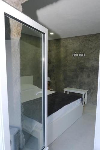 a bedroom with a bed and a glass door at Quinta da Baía - AL in Arrife