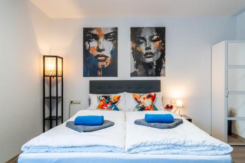 a bedroom with a large white bed with blue pillows at NEW Gästehaus Flora,Kitchen,TV,Free Parking,near Europa Park and Strasbourg in Hohberg