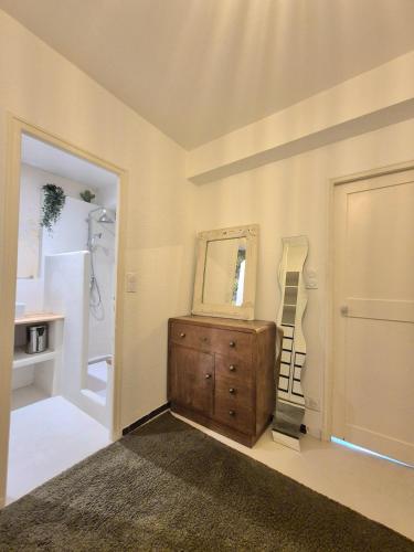 La salle de bains est pourvue d'une commode en bois et d'un miroir. dans l'établissement La Maison des Artistes, à Arles