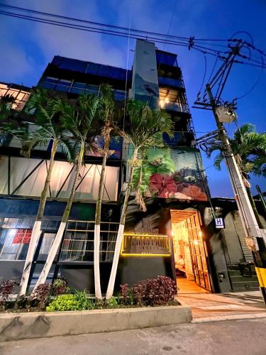a building with palm trees in front of it at Loft Apartamentos Lleras in Medellín