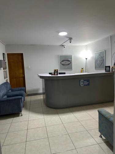 a waiting room with a counter and a blue couch at HOTEL ARMENIA CENTRO , Tenemos AGUA CALIENTE , Gracias in Armenia