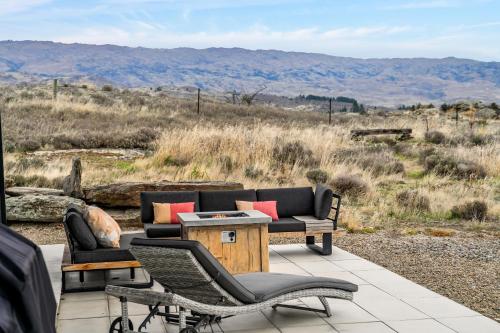 a patio with a couch and chairs and a table at Bridge Hill Beauty - Alexandra Holiday Home in Alexandra