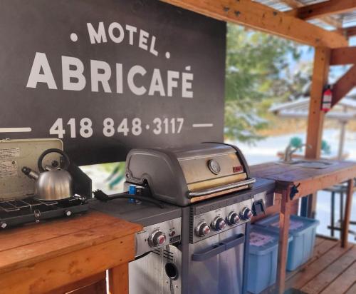 a stove with a tea kettle on it next to a sign at Motel Abricafé in Stoneham