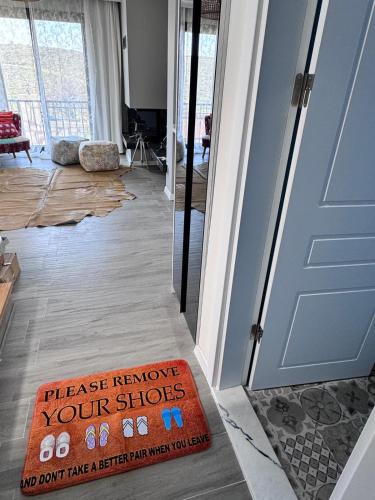 a sign that says please remove your shoes in front of a door at Villa Kataraktis in Seferihisar
