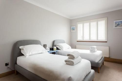 a room with two beds and a window at Sandy Shores - Moments from Blue Flag Sandbanks Beach in Poole
