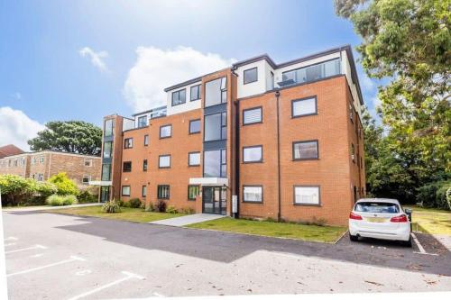 an apartment building with a car parked in front of it at Sandy Shores - Moments from Blue Flag Sandbanks Beach in Poole