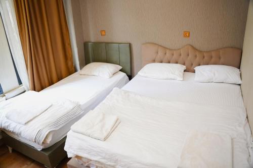 two beds in a room with white sheets and pillows at Family Hotel Taksim in Istanbul