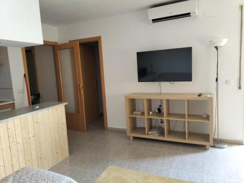 een woonkamer met een flatscreen-tv aan de muur bij Miami Platja cerca del mar in Miami Platja