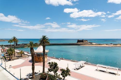 a view of a body of water with palm trees at Blue Marina Suites - Boutique Apartments in Arrecife