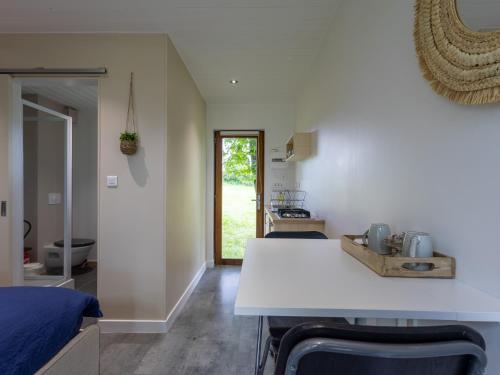 une cuisine et un salon avec un comptoir blanc dans l'établissement La Cafoutche de Minus rénovée 2pers, à Gommenec'h