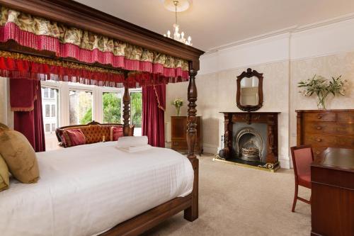 a bedroom with a large bed and a fireplace at Lincoln House Private Hotel in Cardiff