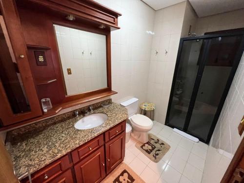 un baño con lavabo e inodoro en Apartamento a 200 metros da Rua Coberta, en Gramado