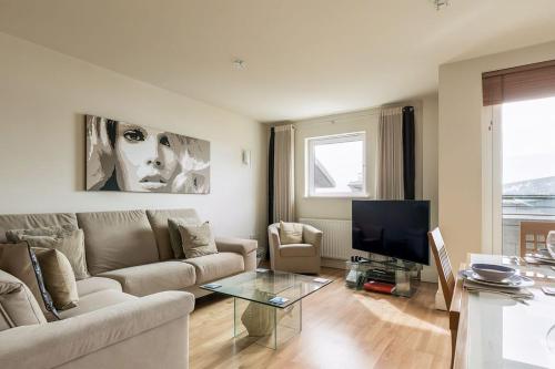 ein Wohnzimmer mit Sofa und Fernseher in der Unterkunft Crow's Nest - On Poole Quay, Parking and Wi-Fi included in Poole