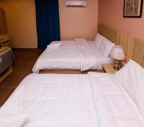 Un pat sau paturi într-o cameră la Pyramids Luxury Hotel