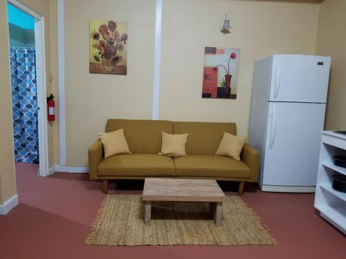 a living room with a couch and a white refrigerator at Careffe Suites St Lucia in Monchy