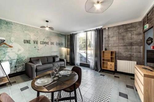 un salon avec un canapé et une table dans l'établissement Studio AVENTURE - Le Méridien #Lave-vaisselle #Wifi #Ventilateur, à Charbonnières-les-Bains