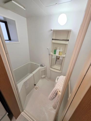 a small bathroom with a tub and a sink at Takaraboshi room 101 Sannomiya10min in Kobe