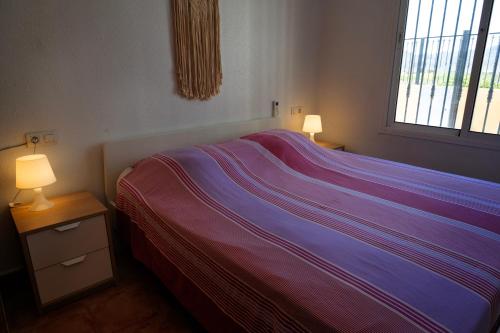 a bedroom with a bed and two lamps on tables at Casa Coco in Mazarrón