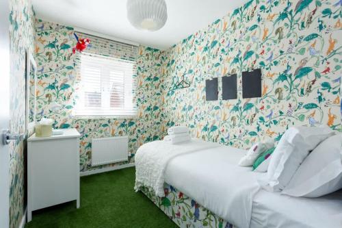 a bedroom with a white bed and floral wallpaper at Heath Reach - Just a short distance to Tower Park in Poole