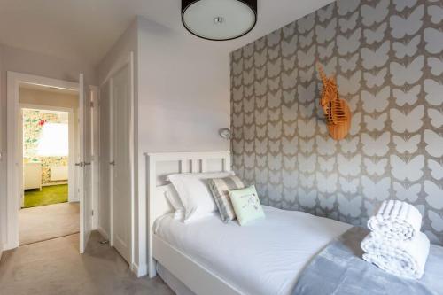 a bedroom with a bed and a wall at Heath Reach - Just a short distance to Tower Park in Poole