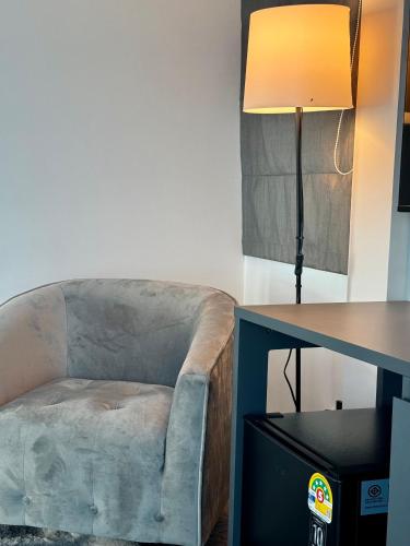 a chair sitting next to a desk with a lamp at myrrh Resort เมอร์รีสอร์ท in Ban Nong Kop