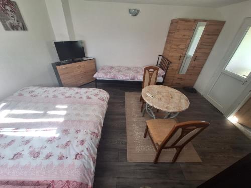 a room with two beds and a table and chairs at Fly & Stay Apartments in Laktaši