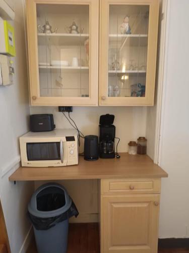 - un comptoir de cuisine avec un four micro-ondes et une poubelle dans l'établissement Chambres privées dans un appartement de 2 pièces à Paris 13e, à Paris