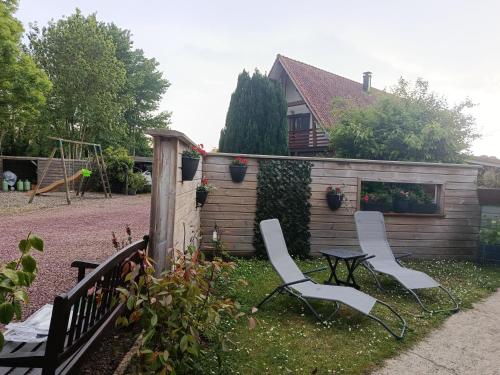two chairs and a table in a backyard at Les épines in Quend-Plage