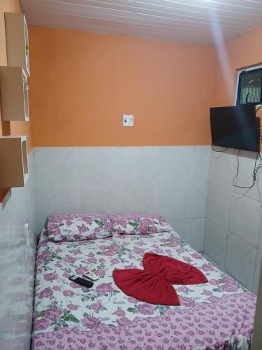 a bedroom with a bed with a flower blanket at Pousada Terra do Sol in Fortaleza