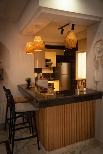 eine Küche mit einer Bar mit Stühlen und Lampen in der Unterkunft Casa Falaise Monastir in Monastir