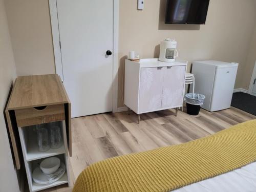 a room with a bed and a microwave and a refrigerator at Motel Abricafé in Stoneham