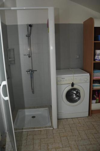 une machine à laver dans une salle de bain avec douche dans l'établissement Maison confortable avec jardin à Lahosse, 90 m², à Lahosse