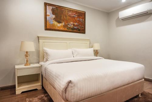 a bedroom with a bed and a painting on the wall at PC Residences Gulberg Lahore in Lahore
