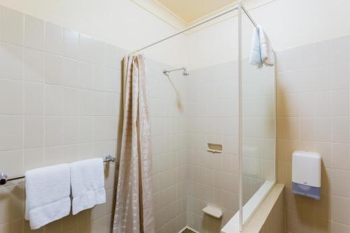y baño con ducha y cortina de ducha. en Markets Hotel, en Sídney