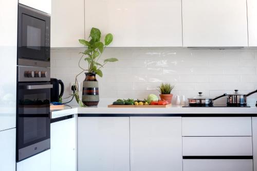 a white kitchen with white cabinets and a counter top at PC Residences Gulberg Lahore in Lahore