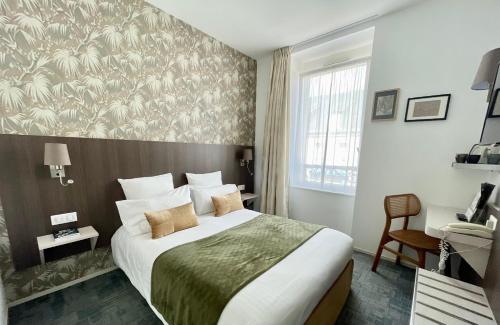 a hotel room with a large bed and a window at Cit'Hotel Hôtel de France et d'Europe in Concarneau