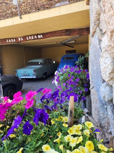 two old cars parked in a garage with flowers at CASA DA CASADA VILLA RURAL - FOZ DO DOURO by LW in Foz do Sousa