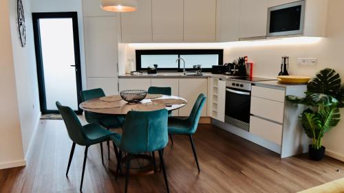 a kitchen with a table and chairs in a room at Oak Retreat House in Lagoa