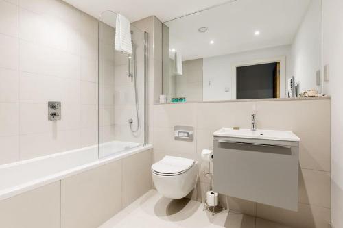 a white bathroom with a toilet and a sink at Endless Summer - Spacious Living Space on Poole Quay in Poole