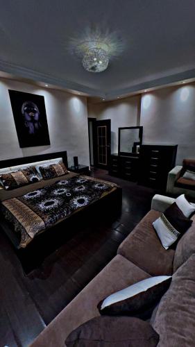 a large bedroom with a bed and a couch at شقه مفروشه in Jurf ad Darāwīsh