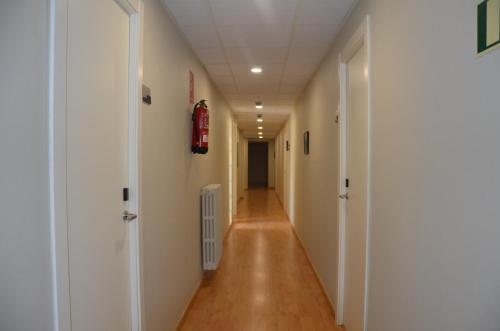 a long hallway with white walls and wooden floors at Hotel Balaguer in Balaguer