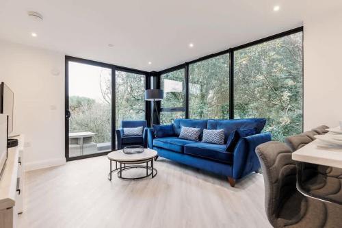 a living room with a blue couch and a table at Aurora South - Short Walk to Ashley Cross in Poole